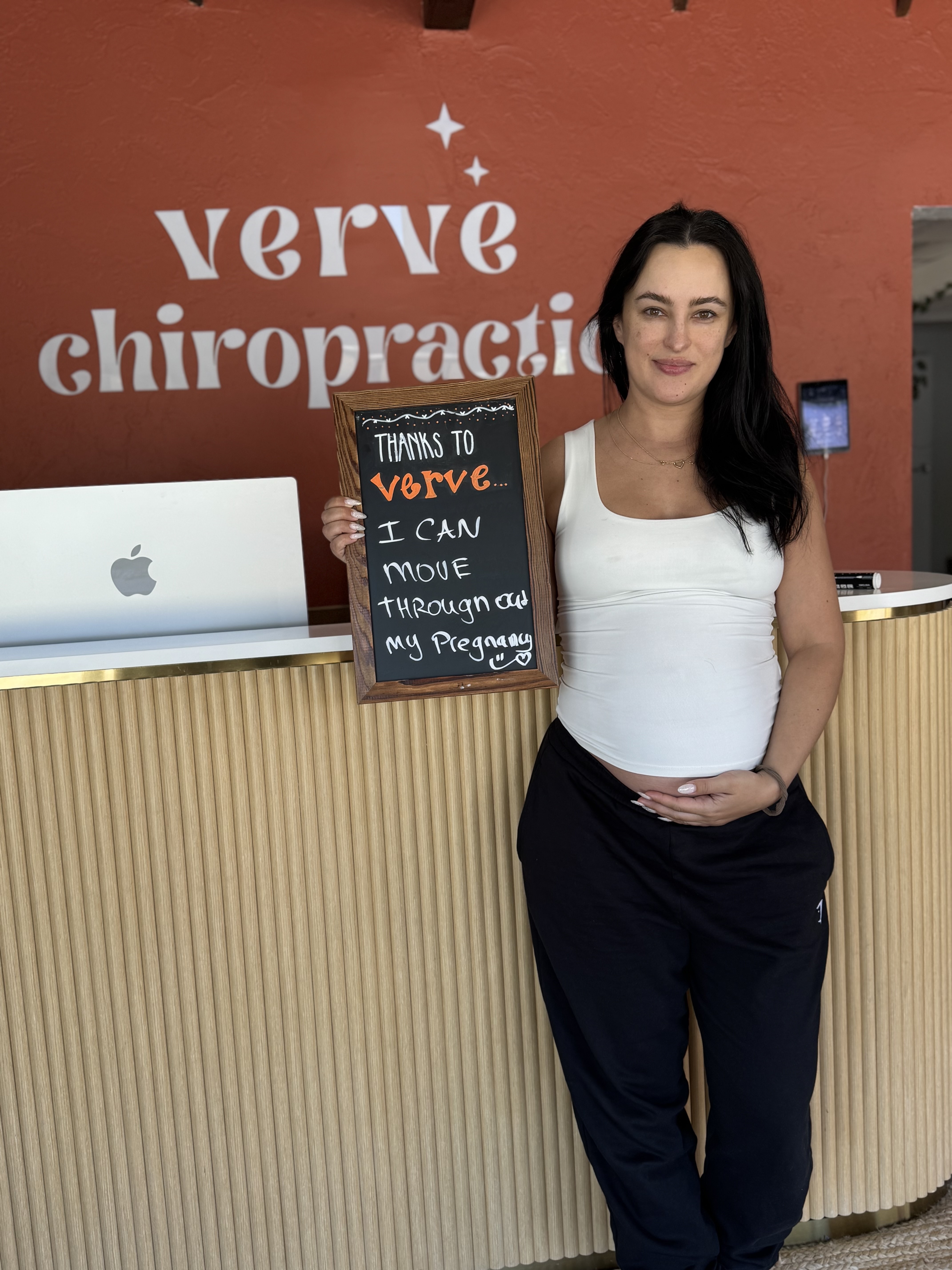 Pregnant mama at Verve holding chalkboard: Thanks to Verve I can move through my pregnancy